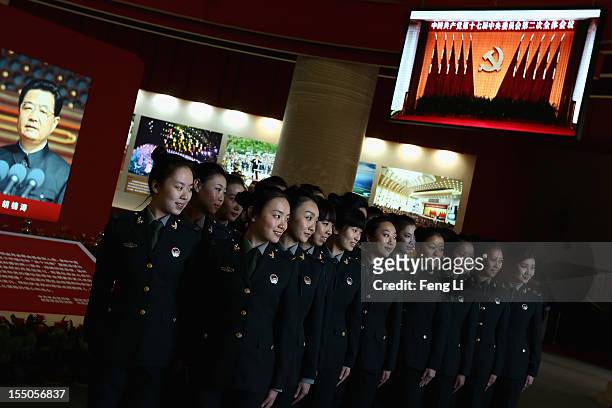 Female soldiers pose for photos in front of the portrait of China's President Hu Jintao as visiting an exhibition entitled "Scientific Development...