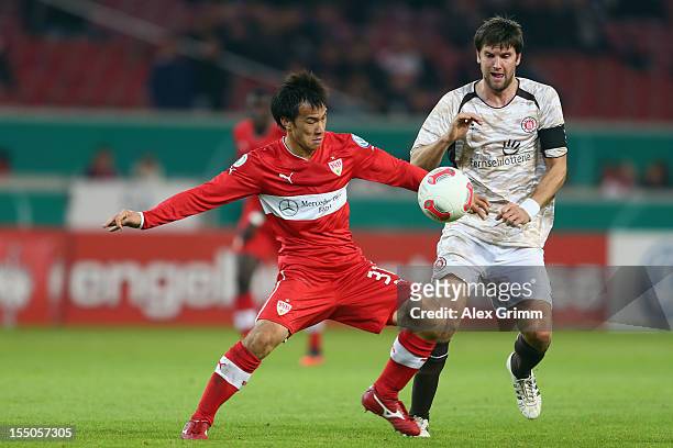 Shinji Okazaki of Stuttgart is challenged by Florian Bruns of St. Pauli during the second round match of the DFB Cup between VfB Stuttgart and FC...