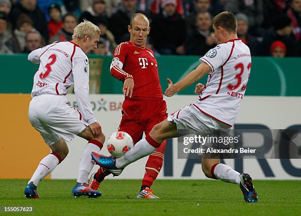 Arjen Robben of Bayern Muenchen fights for the ball with Leon Jessen and Dominique Heintz of Kaiserslautern during the DFB Cup second round match...