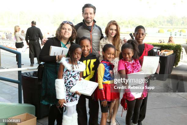 Actor Ian Bohen and actress Holland Roden take photos with kids at Children Mending Hearts Kids' Breakfast at the Track Event at Santa Anita Park on...