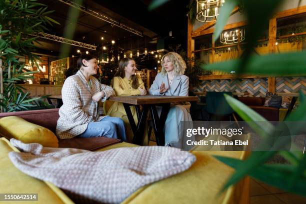 female friends meeting in a coffee shop, talking, laughing - istra istrinsky district stock pictures, royalty-free photos & images