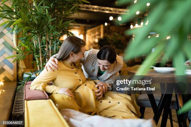 woman greets her pregnant friend in a restaurant - istra istrinsky district stock pictures, royalty-free photos & images