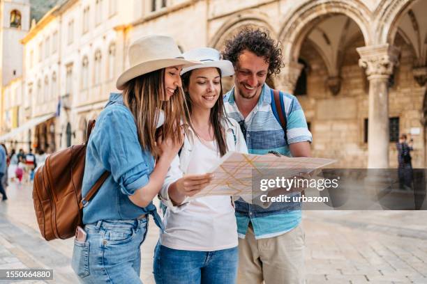 three young friends reading a map on the street in dubrovnik - croatia map stock pictures, royalty-free photos & images