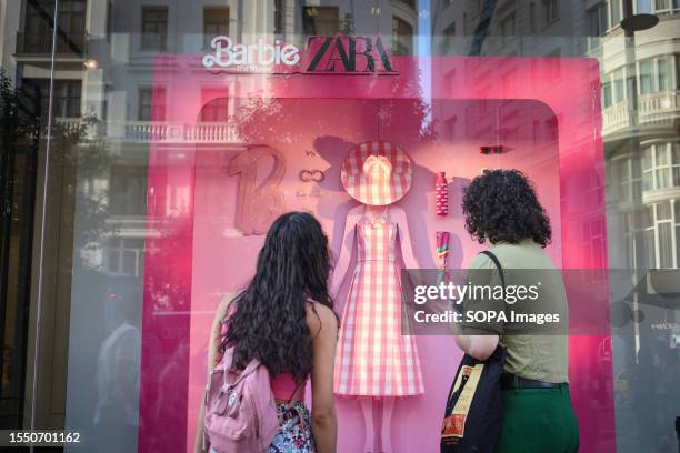 Girl with her mother look at the window of the Zara store on Gran Vía street in Madrid with an advertising campaign for Barbie for the premiere of a...