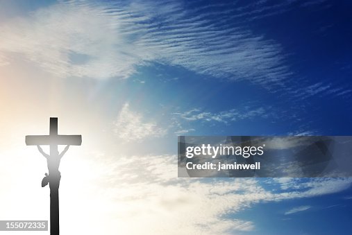 Crucifix against dramatic sky and sunbeam rays Crucifix against dramatic sky and sunbeam rays