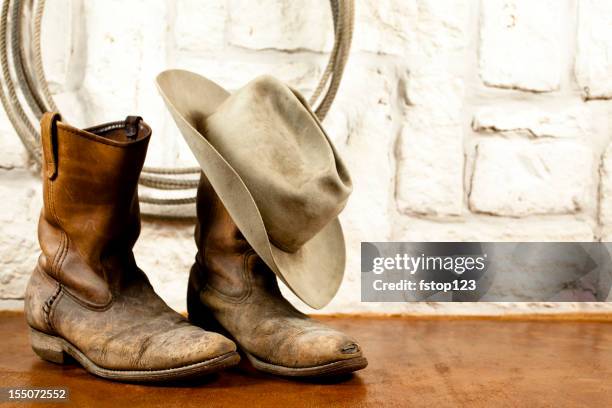 botas de vaquero y sombrero. arenisca fondo de austin - sombrero de vaquero fotografías e imágenes de stock