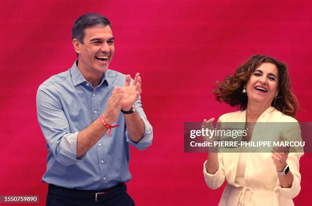 Spanish Prime Minister and Socialist Party candidate for re-election Pedro Sanchez applauds next to Spain's Minister of Budget Maria Jesus Montero...