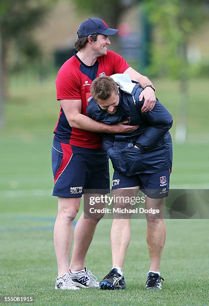 Demons coach Mark Neeld is hugged by assistant coach Leigh Brown during a Melbourne Demons AFL training session at Gosch's Paddock on November 1,...