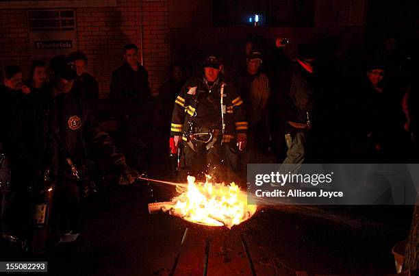 Firefighters break up a bonfire October 31, 2012 in New York City. At least 15 people were reported killed in the United States by Sandy as millions...