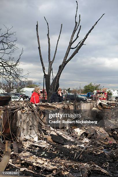 Family members check out the damage to their home after Superstorm Sandy swept through on October 31, 2012 in the Breezy Point neighborhood of the...