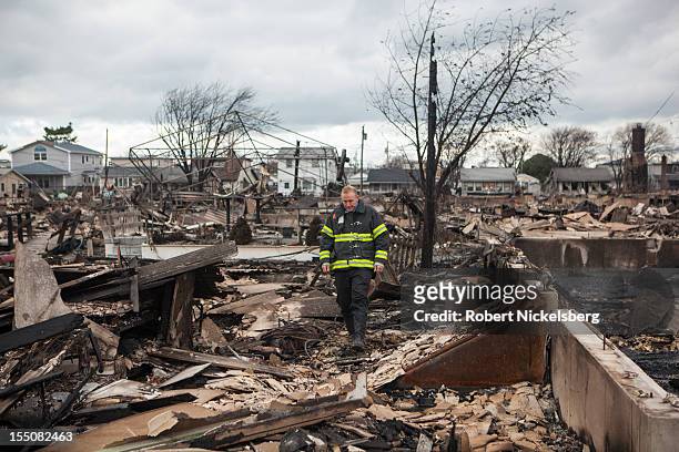 Member of the FDNY inspects the damage to his home after Superstorm Sandy swept through on October 31, 2012 in the Breezy Point neighborhood of the...