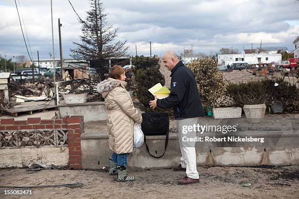 An insurance appraiser , speaks with a woman who lost her home in a fire after Superstorm Sandy swept through on October 31, 2012 in the Breezy Point...