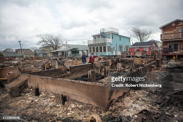 Residents check out the fire damage to their homes after Superstorm Sandy swept through on October 31, 2012 in the Breezy Point neighborhood of the...
