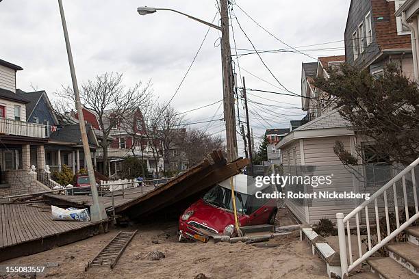 Mini Cooper lies stranded against a pole in Rockaway Beach after Superstorm Sandy swept through on October 31, 2012 in the Queens borough of New York...