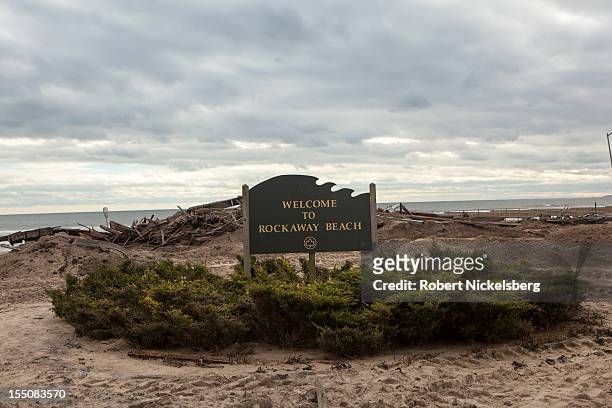 Sign for Rockaway Beach lies in front of the ruined boardwalk after Superstorm Sandy swept through on October 31, 2012 in the Queens borough of New...