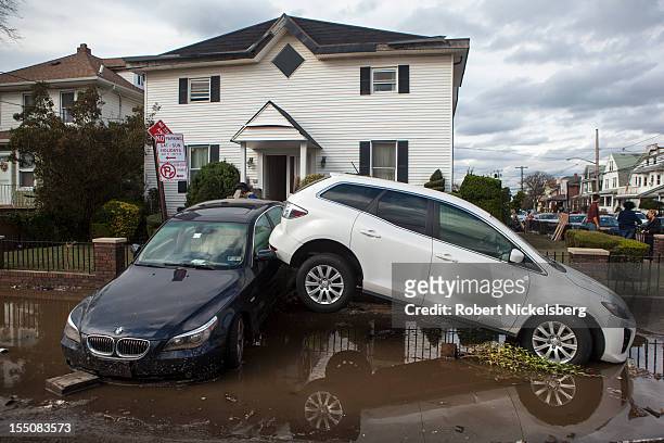 Two cars lie against each other near Rockaway Beach after Superstorm Sandy swept through on October 31, 2012 in the Queens borough of New York City....