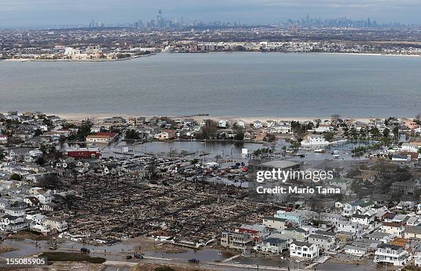 The remains of burned homes are surrounded by water with the Manhattan skyline in the distance after Superstorm Sandy on October 31, 2012 in the...