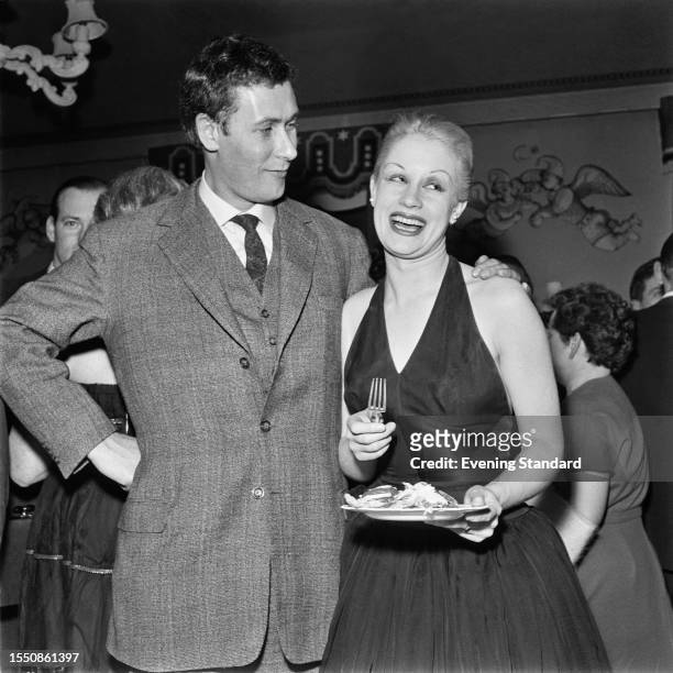 British playwright John Osborne puts an arm around his wife, actress Mary Ure , at a party to celebrate the opening performance of Shakespeare's...