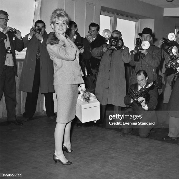 French actress Brigitte Bardot pictured with photographers on arrival in London to film 'Babette Goes to War', April 9th 1959.