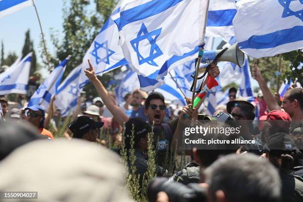 July 2023, Israel, Jerusalem: Demonstrators stand near the road leading to the Knesset, where Israel's parliament was expected to take a final vote...