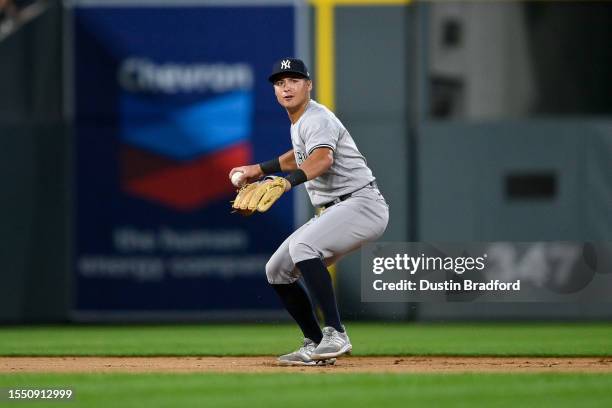 Anthony Volpe of the New York Yankees throws to first base after fielding a ground ball in the eighth inning of a game against the Colorado Rockies...