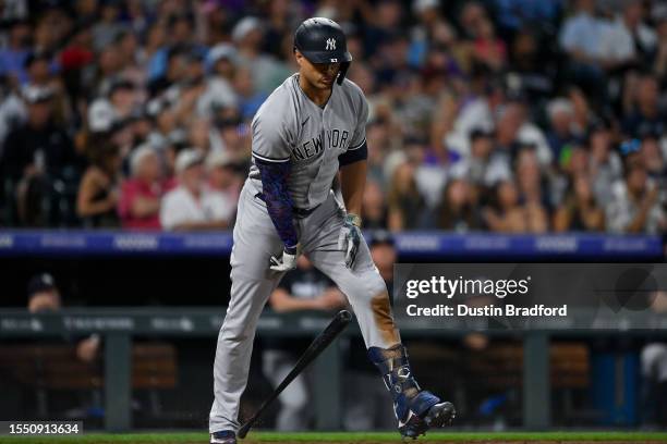 Giancarlo Stanton of the New York Yankees slams a bat as he reacts after flying out in the eighth inning of a game against the Colorado Rockies at...