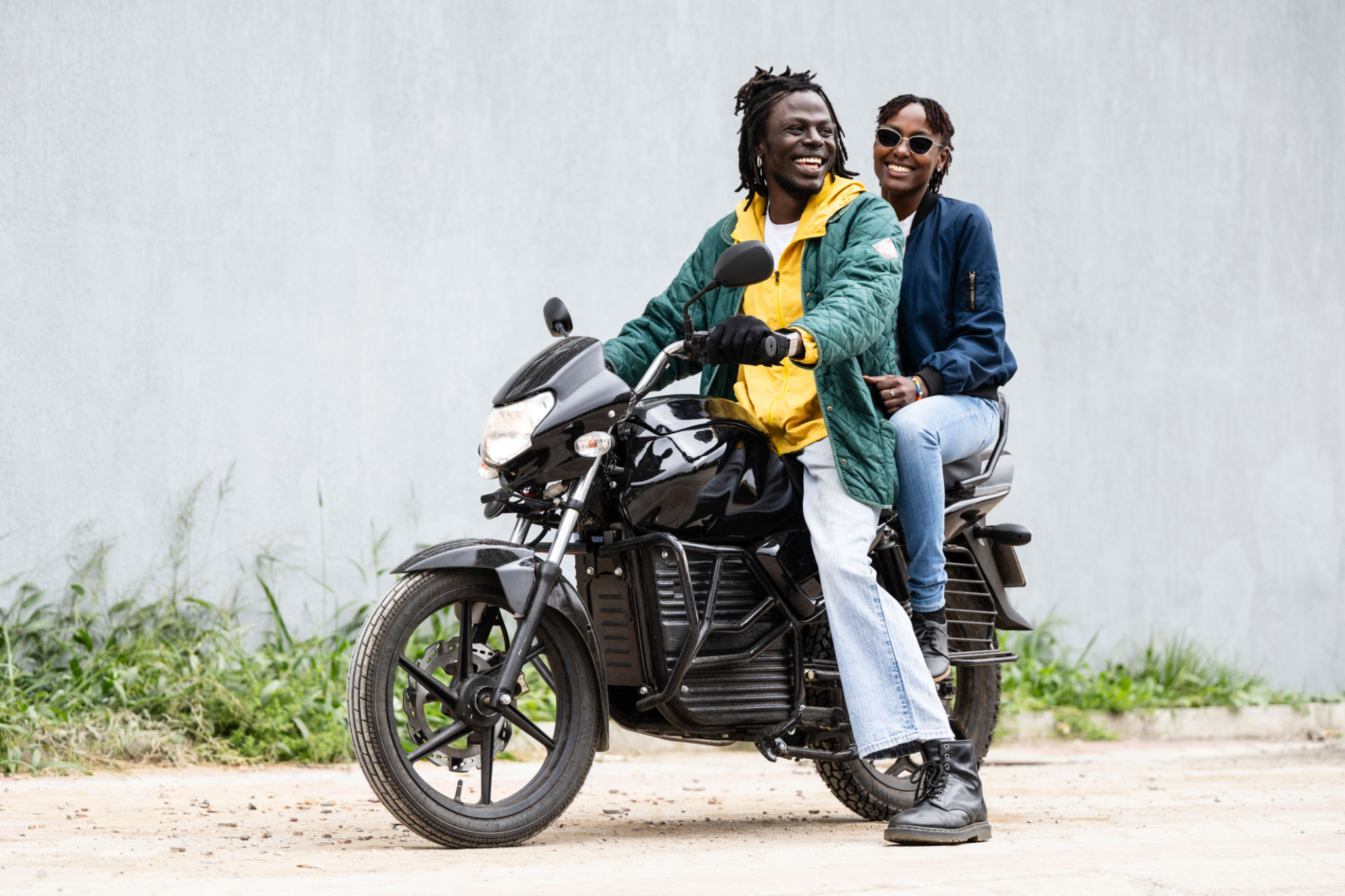 Smiling couple astride electric motorbike in Nairobi Smiling couple astride electric motorbike in Nairobi