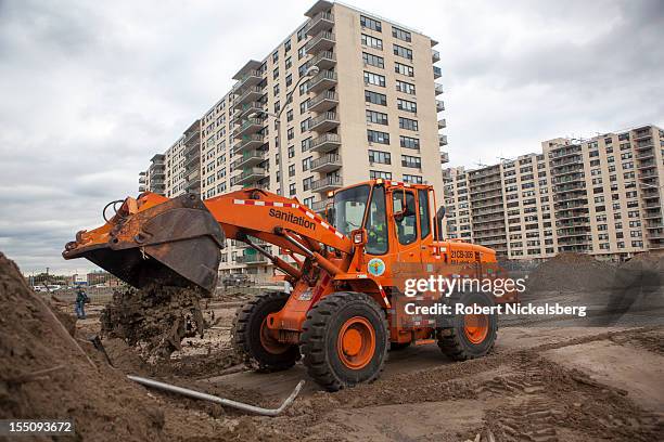 Bucket loader from the New York Department of Sanitation moves piles of sand in Rockaway Beach after Superstorm Sandy hit during the previous night...