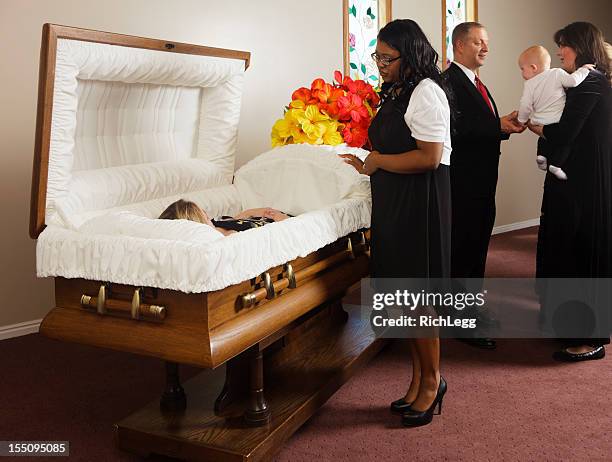 family receiving guests at a funeral - coffin stockfoto's en -beelden