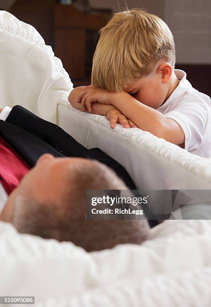 grieving little boy - boy lying dead stockfoto's en -beelden