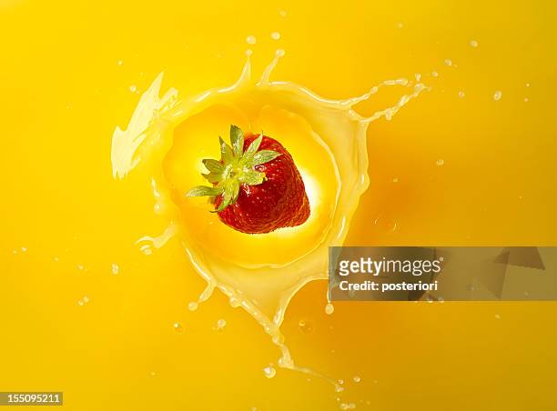 strawberry falling into juice - orange juice stock pictures, royalty-free photos & images