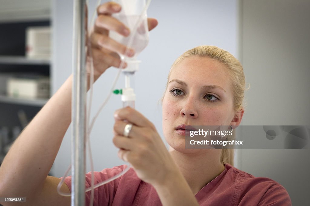 Female blond nurse is preparing an infusion