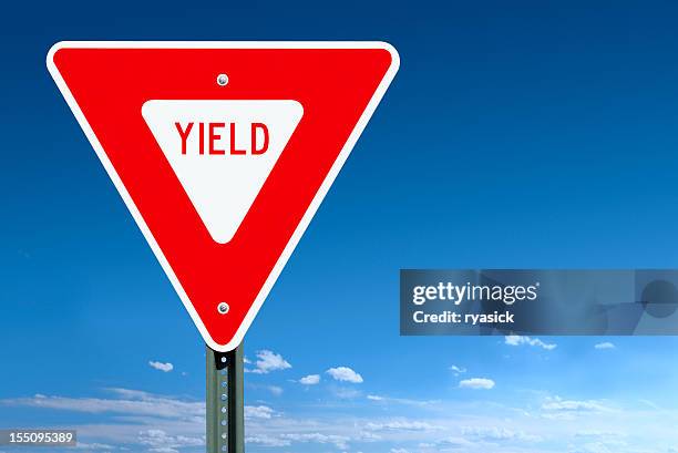 yield road sign post over a blue sky - give way 個照片及圖片檔