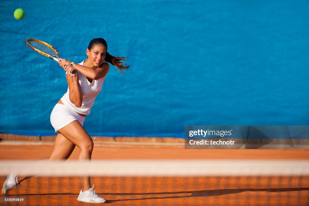 Female tennis player hitting the ball