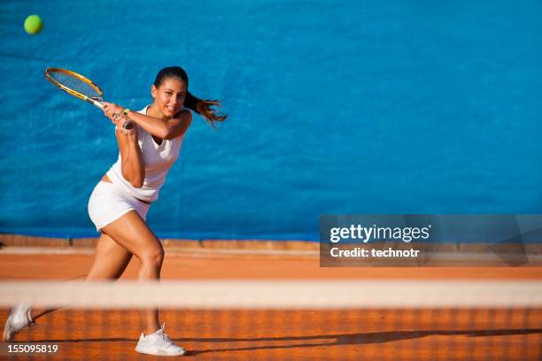 female tennis player hitting the ball - blue tennis court stock pictures, royalty-free photos & images