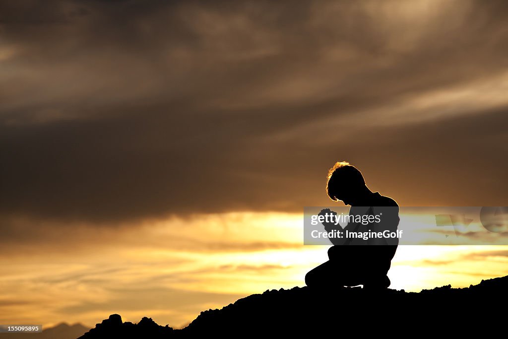 Silhouette of Young Caucasian Boy Praying