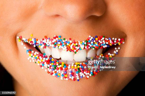 girl's lips coated with colorful candy sprinkles - candy lips stock pictures, royalty-free photos & images