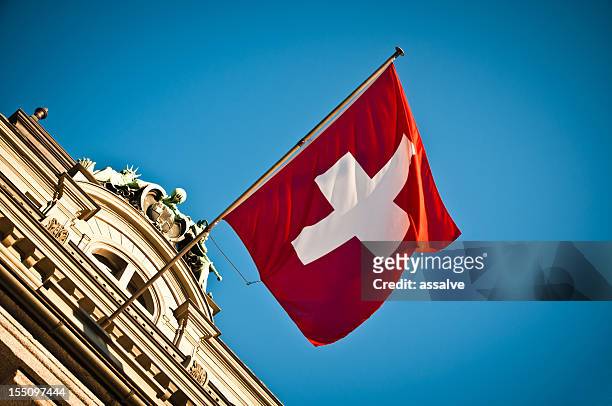 bandera suiza saludar con la mano en el histórico edificio - zwitserland fotografías e imágenes de stock