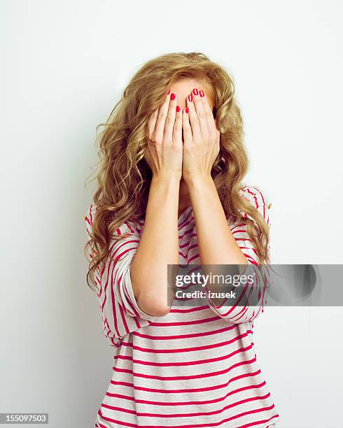 young woman hiding her face with her hands - hålla huvudet i händerna bildbanksfoton och bilder