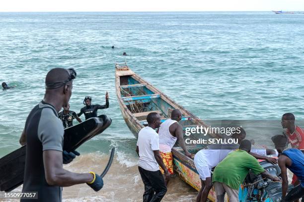 Graphic content / Senegalese rescue personnel and local fishermen prepare a pirogue for a rescue operation in Ouakam, in Dakar on July 24, 2023 after...