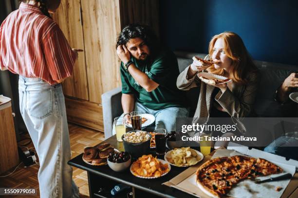 diverse group of young adults gather around table with array of delicious treats - pizza temptation stock pictures, royalty-free photos & images