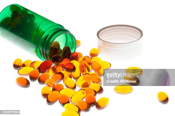 spilled amber colored vitamins - saw palmetto supplement stock pictures, royalty-free photos & images