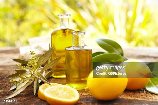 bottiglie di olio da massaggio alla spa, all'aperto con limoni - aromaterapia foto e immagini stock