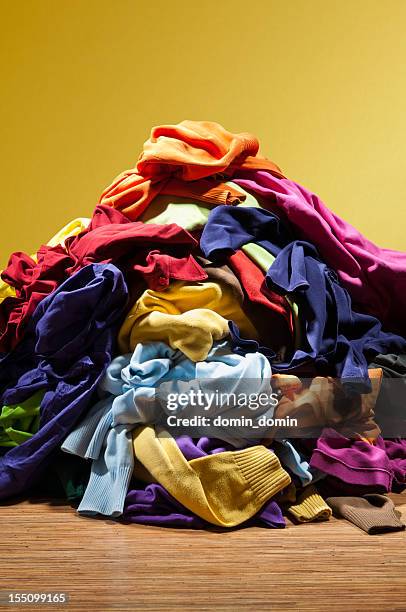 riesigen haufen haufen von schmutzigen klamotten auf goldenem hintergrund - pile of clothes stock-fotos und bilder