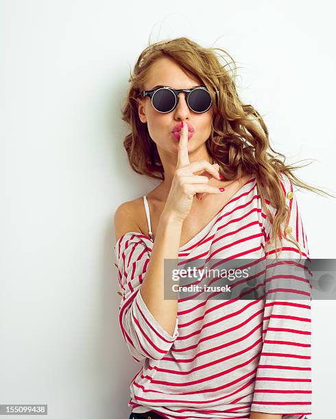 young woman shushing - woman with finger on lips stock pictures, royalty-free photos & images