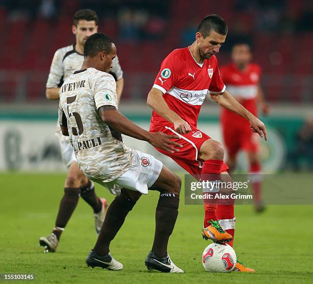 Vedad Ibisevic of Stuttgart is challenged by Christopher Avevor of St. Pauli during the second round match of the DFB Cup between VfB Stuttgart and...