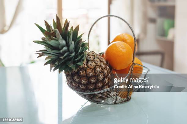 basket with pineapple and oranges on table in kitchen - oranges in basket at food market stock pictures, royalty-free photos & images