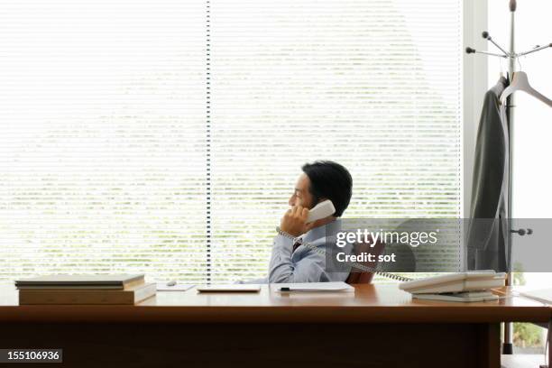 mature businessman on phone in office - telephone receiver fotografías e imágenes de stock