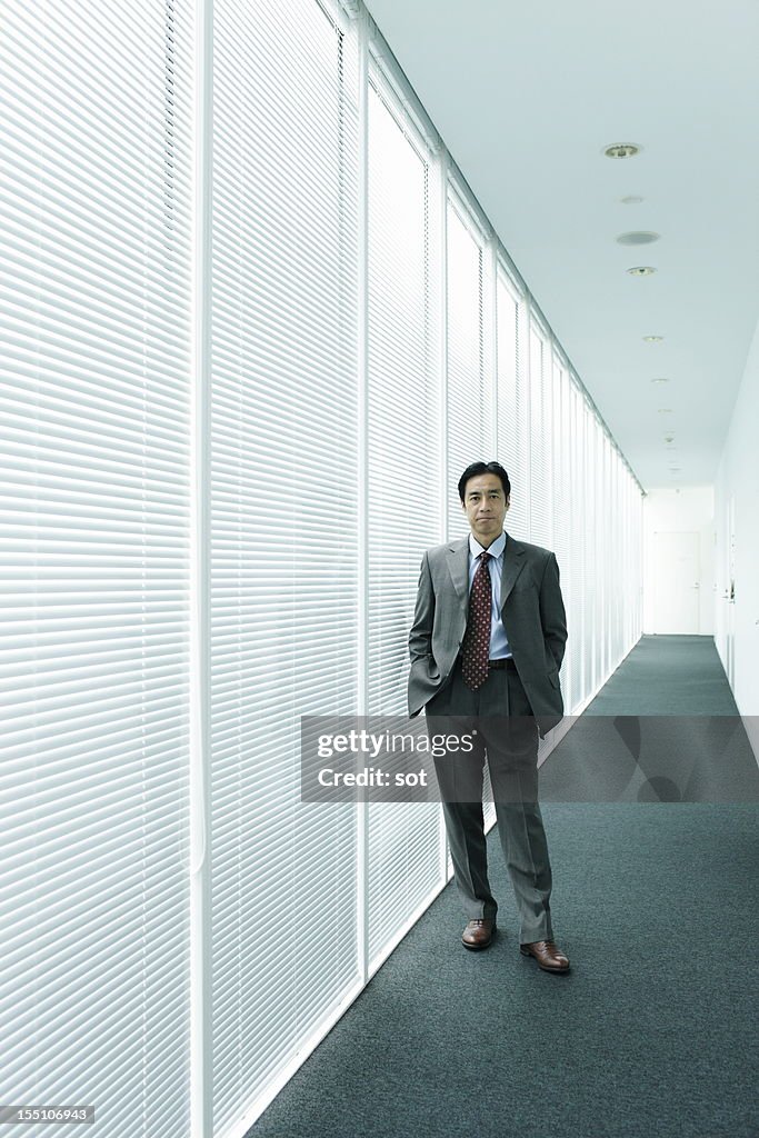 Mature businessman standing in office hallway