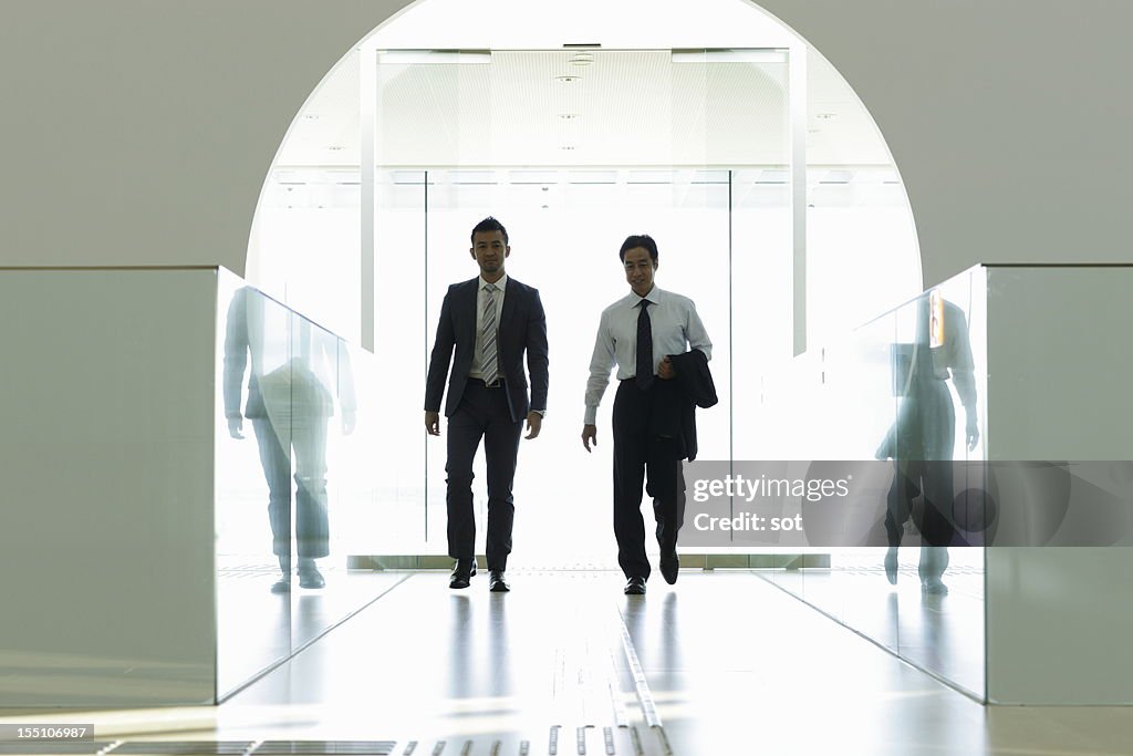 Coworkers walking in entrance hallway of office
